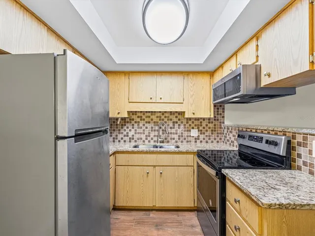 a kitchen with stainless steel appliances granite countertop a stove a refrigerator and a sink