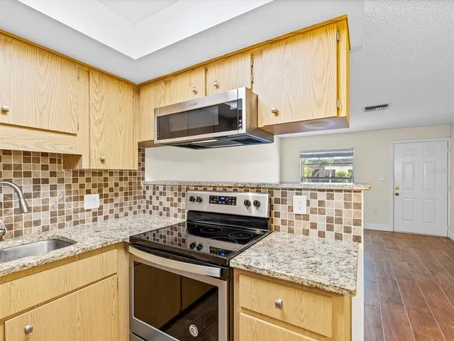 a kitchen with stainless steel appliances granite countertop a sink stove and microwave