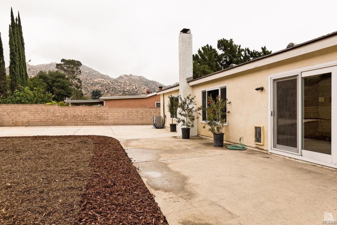 6449 Keystone Street Simi Valley, CA 93063 - Photo 17 of 20 a view of a house with backyard and trees in the background