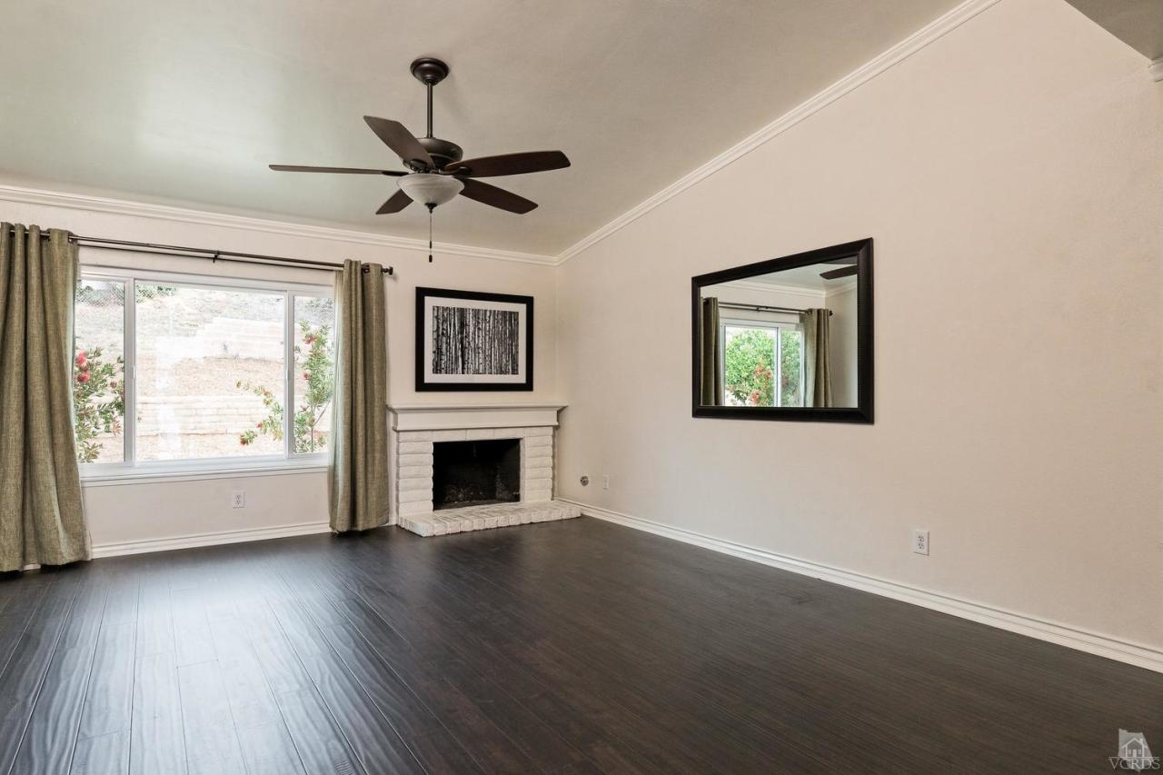 6449 Keystone Street Simi Valley, CA 93063 - Photo 3 of 20 a view of a livingroom with wooden floor a ceiling fan and windows