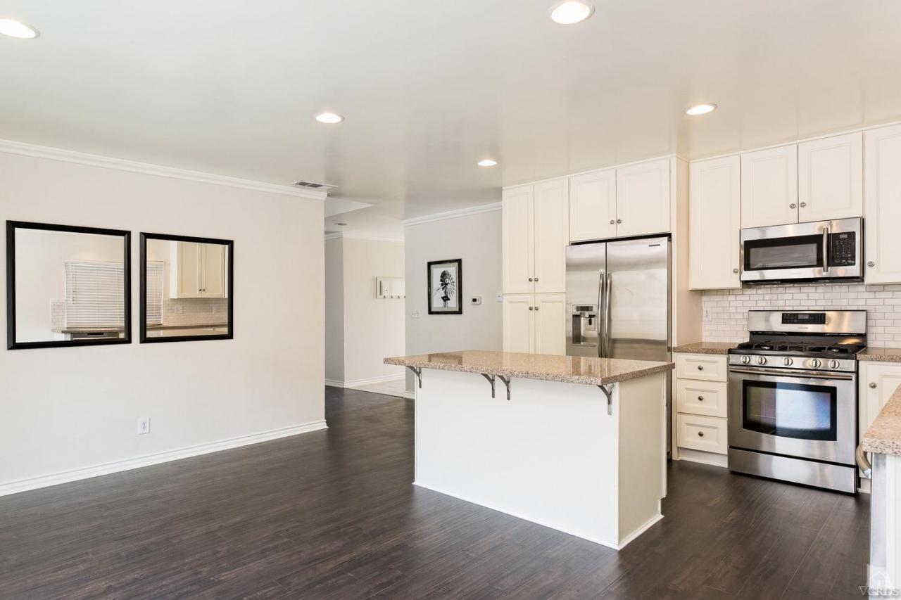 6449 Keystone Street Simi Valley, CA 93063 - Photo 7 of 20 a kitchen with stainless steel appliances kitchen island a stove a sink and a refrigerator
