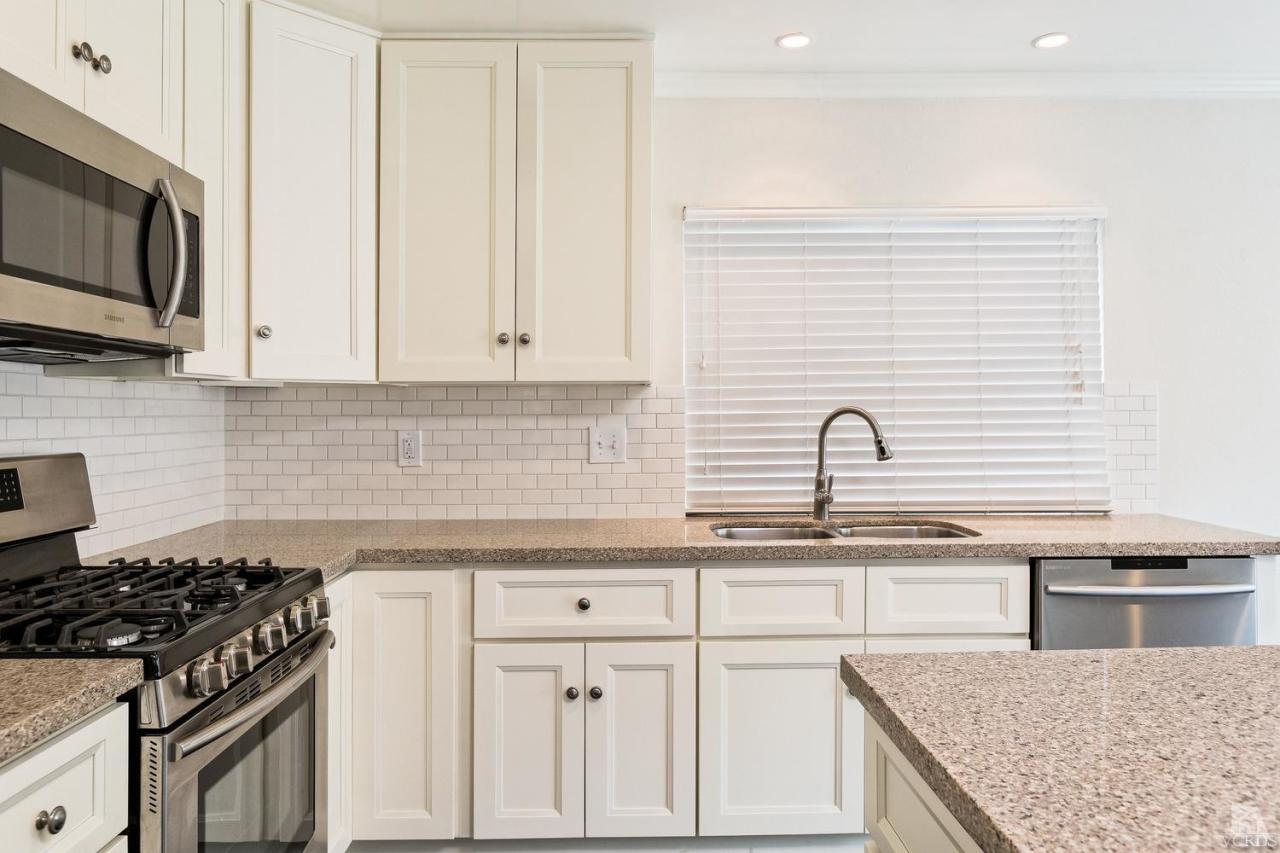 6449 Keystone Street Simi Valley, CA 93063 - Photo 8 of 20 a kitchen with stainless steel appliances granite countertop a sink stove oven and white cabinets