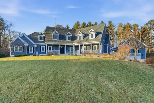 a view of a house with a big yard and large trees