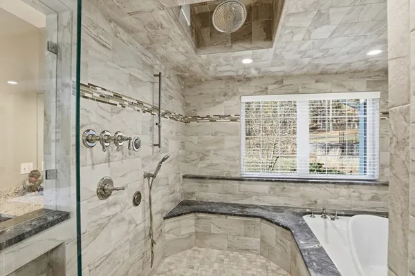 a bathroom with a granite countertop sink and a shower