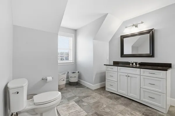 a bathroom with a toilet sink and mirror