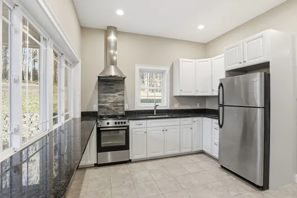 a kitchen with stainless steel appliances granite countertop a refrigerator and a stove