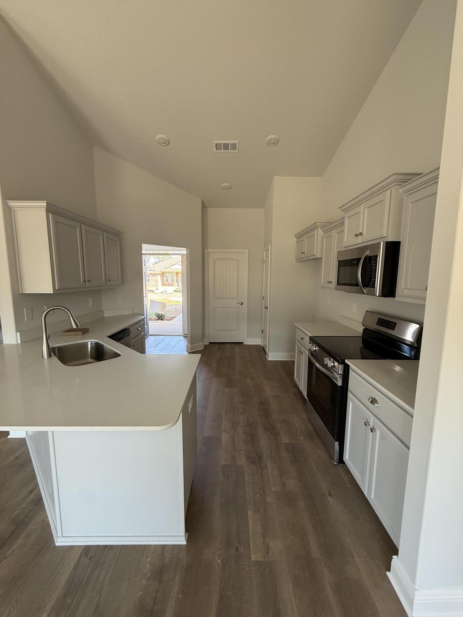 6013 Crocket Cove Crestview, FL 32539 - Photo 14 of 27 a large kitchen with kitchen island a sink dishwasher stove and refrigerator