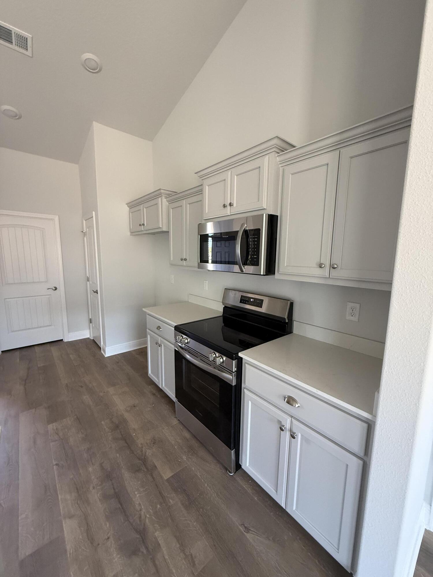 6013 Crocket Cove Crestview, FL 32539 - Photo 15 of 27 a kitchen with stainless steel appliances granite countertop white cabinets a sink a stove a microwave and a refrigerator