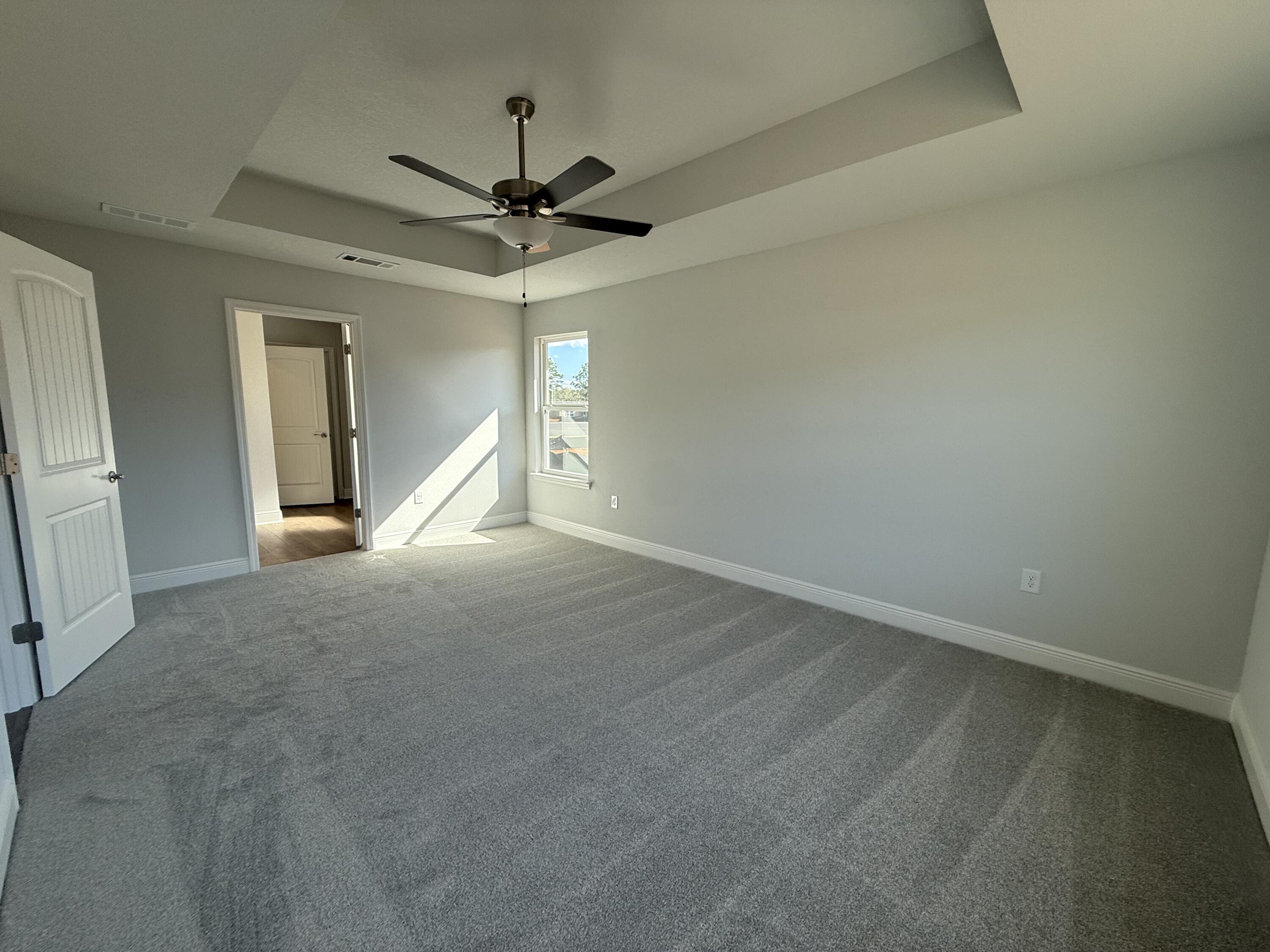 6013 Crocket Cove Crestview, FL 32539 - Photo 21 of 27 an empty room with a ceiling fan and windows
