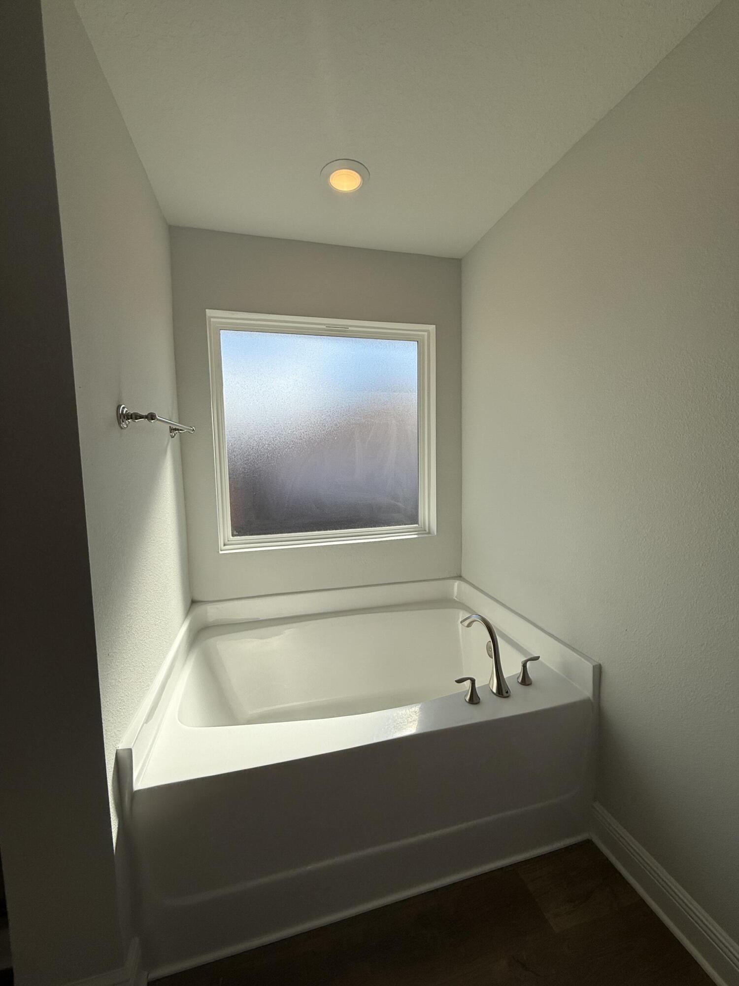 6013 Crocket Cove Crestview, FL 32539 - Photo 23 of 27 a bathroom with a bathtub and a window