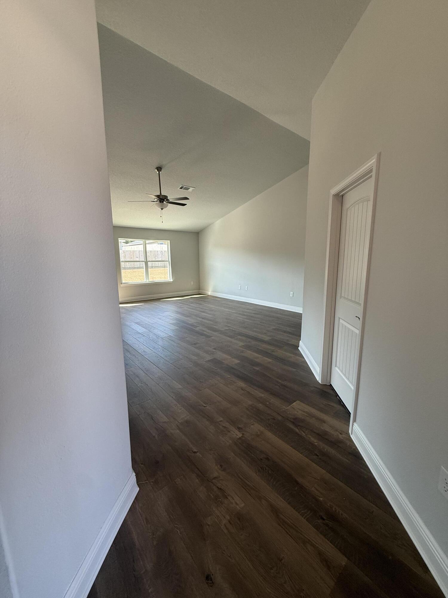6013 Crocket Cove Crestview, FL 32539 - Photo 5 of 27 an empty room with wooden floor and windows