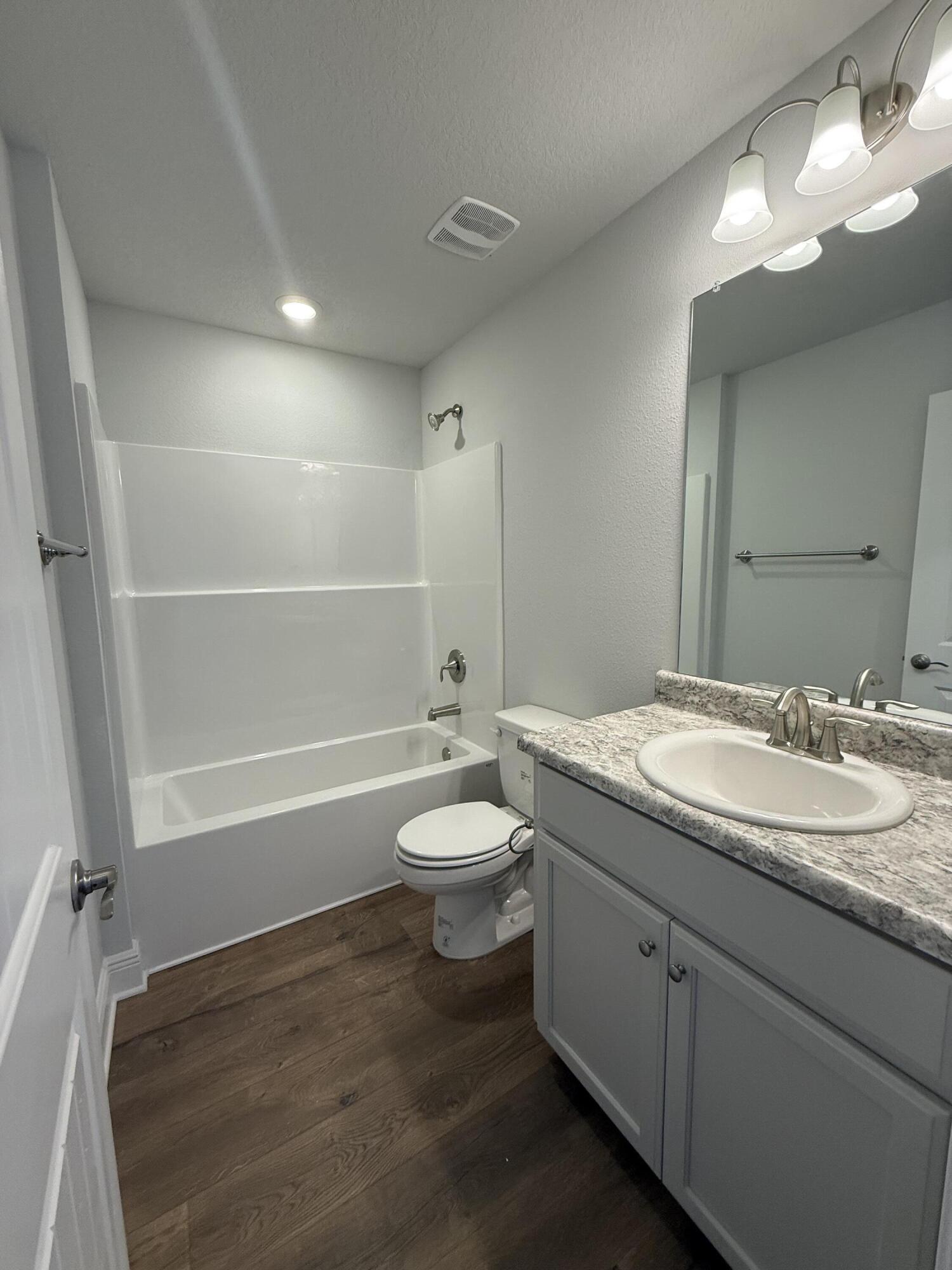 6013 Crocket Cove Crestview, FL 32539 - Photo 9 of 27 a bathroom with a granite countertop toilet a sink and a mirror