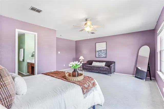 a bedroom with a bed table chair and a window