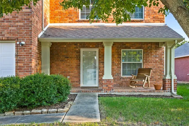 a patio with a table and chairs and potted plants