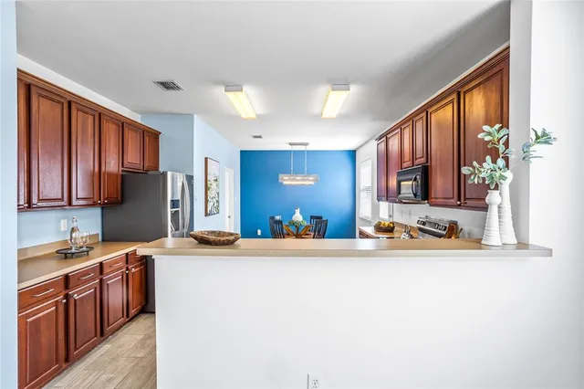 a kitchen with stainless steel appliances granite countertop a refrigerator sink and stove