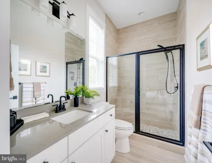 a bathroom with a double vanity sink toilet and shower