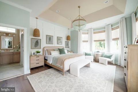 a spacious bedroom with a large bed and a chandelier