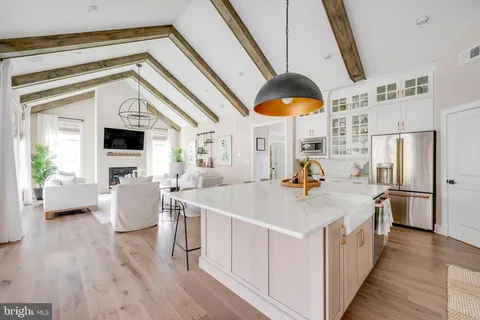 a kitchen with stainless steel appliances a white cabinets and a chandelier