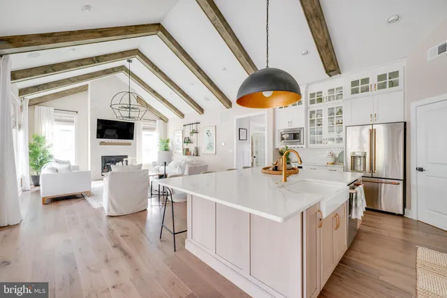 a kitchen with stainless steel appliances a white cabinets and a chandelier