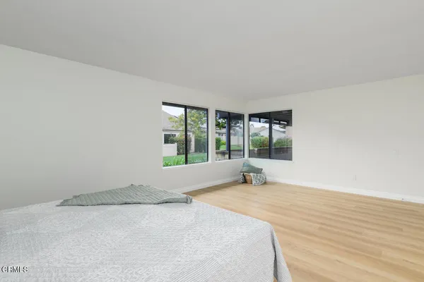a large white bed in a room next to a window