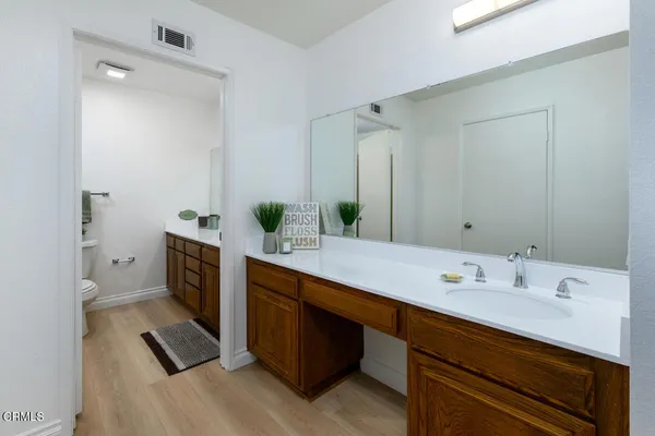 a spacious bathroom with a double vanity sink a mirror and shower