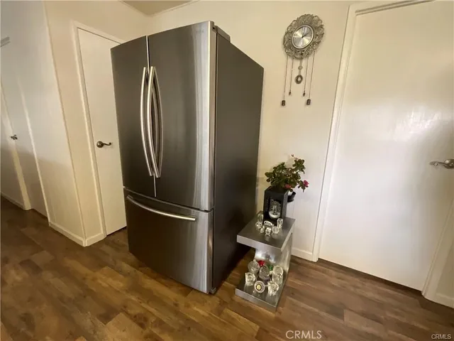 a kitchen with a refrigerator and wooden floor