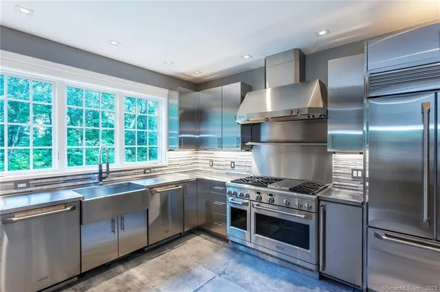 a kitchen with stainless steel appliances granite countertop a stove and a sink