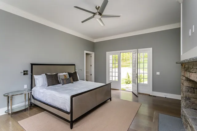 a bedroom with a large bed and a chandelier fan