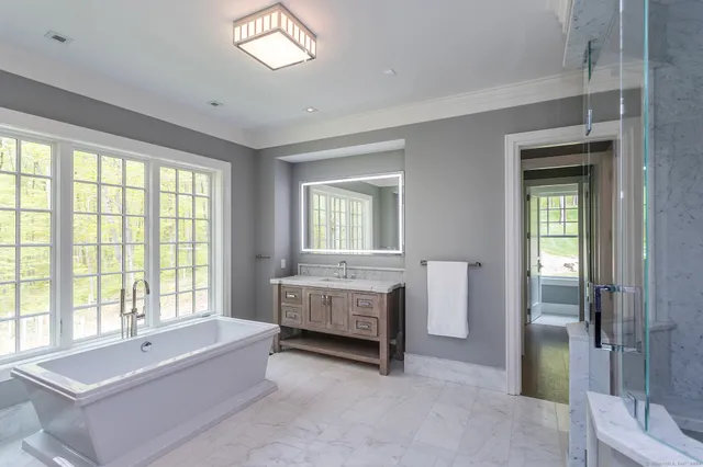 a spacious bathroom with a tub sink and shower