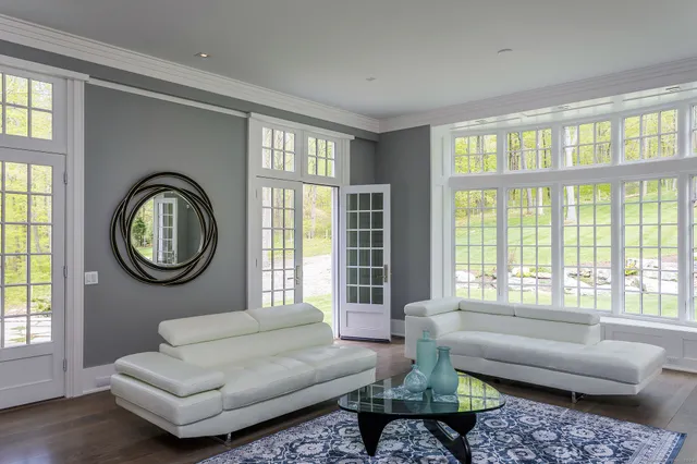 a living room with furniture a fireplace and a large window