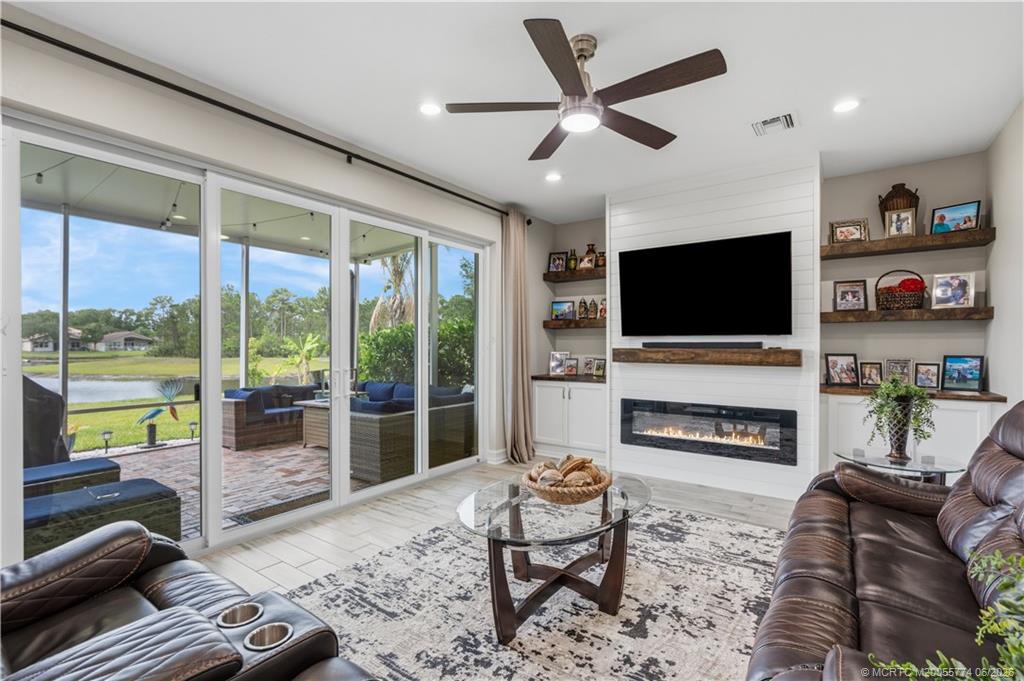 1268 Southeast Kirk Street Stuart, FL 34997 - Photo 28 of 63 a living room with furniture a flat screen tv and a fireplace