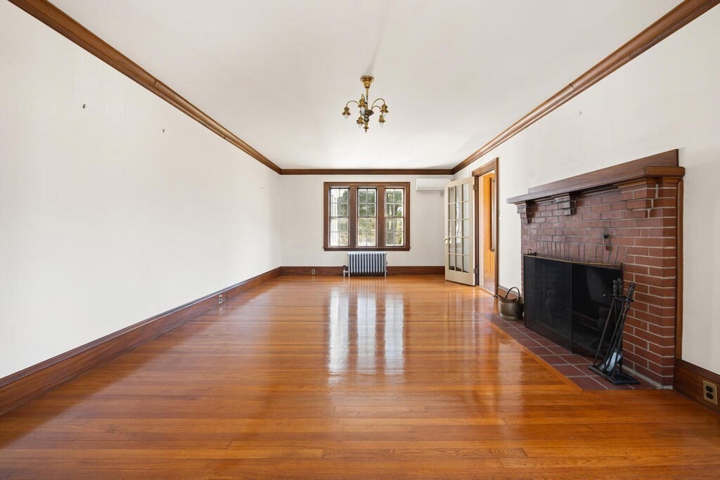 8 Spring Street Lexington, MA 02421 - Photo 11 of 35 a view of empty room with wooden floor and fireplace
