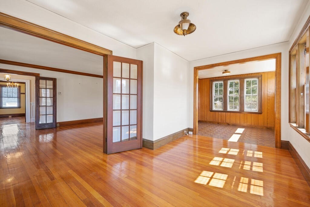 8 Spring Street Lexington, MA 02421 - Photo 8 of 35 a view of an empty room with wooden floor and a window