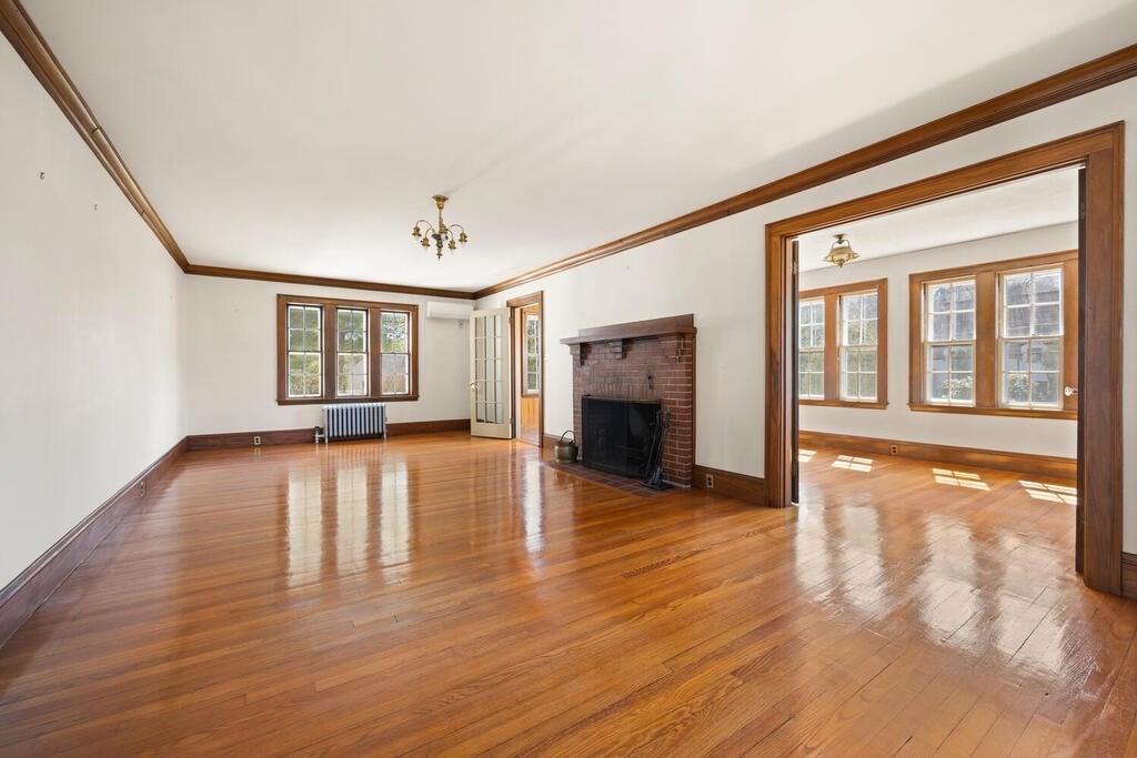 8 Spring Street Lexington, MA 02421 - Photo 9 of 35 a view of empty room with wooden floor and fireplace