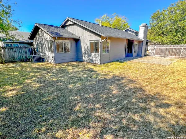 a view of a house with a yard and wooden fence