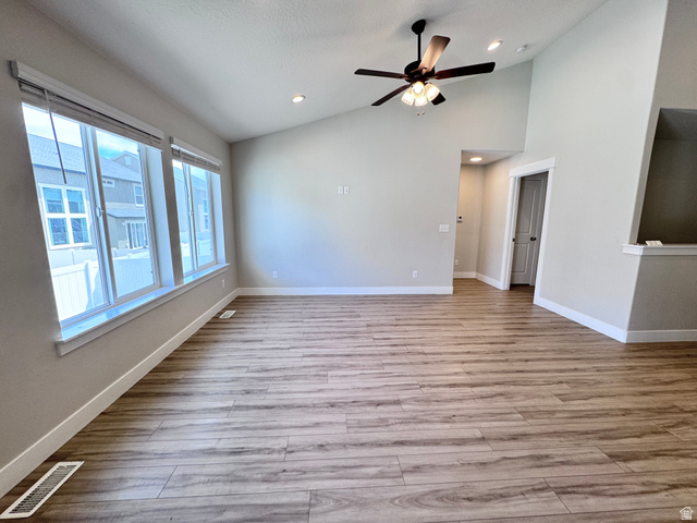 12339 Remy Road, Unit 422 Herriman, UT 84096 - Photo 18 of 36 Empty room featuring ceiling fan, light wood-style floors, vaulted ceiling, and recessed lighting