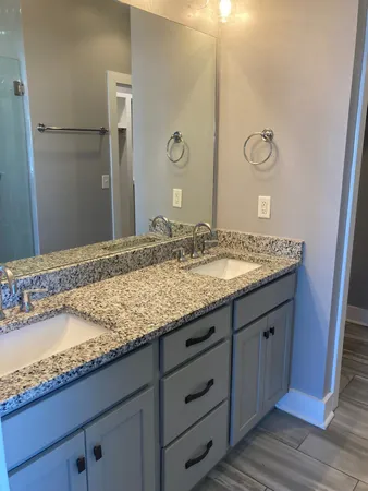 a bathroom with a granite countertop sink and a mirror