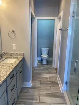 a bathroom with a granite countertop sink toilet and shower