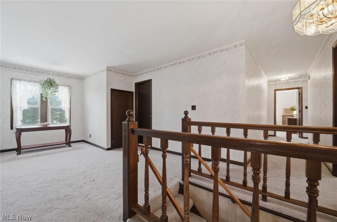 17452 Huntley Road Windsor, OH 44099 - Photo 24 of 49 Corridor featuring an upstairs landing, light carpet, and a chandelier
