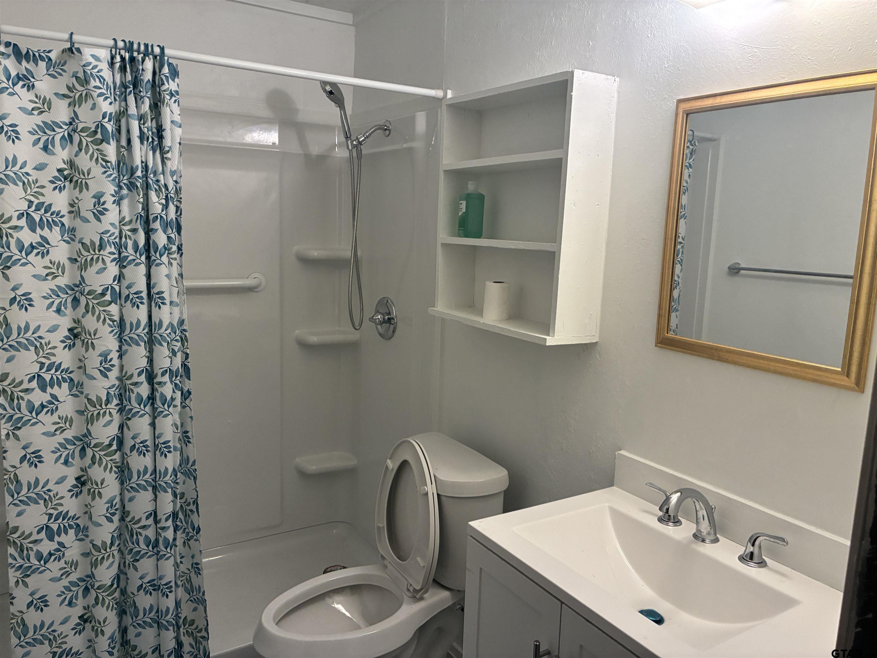 a bathroom with a toilet sink and mirror