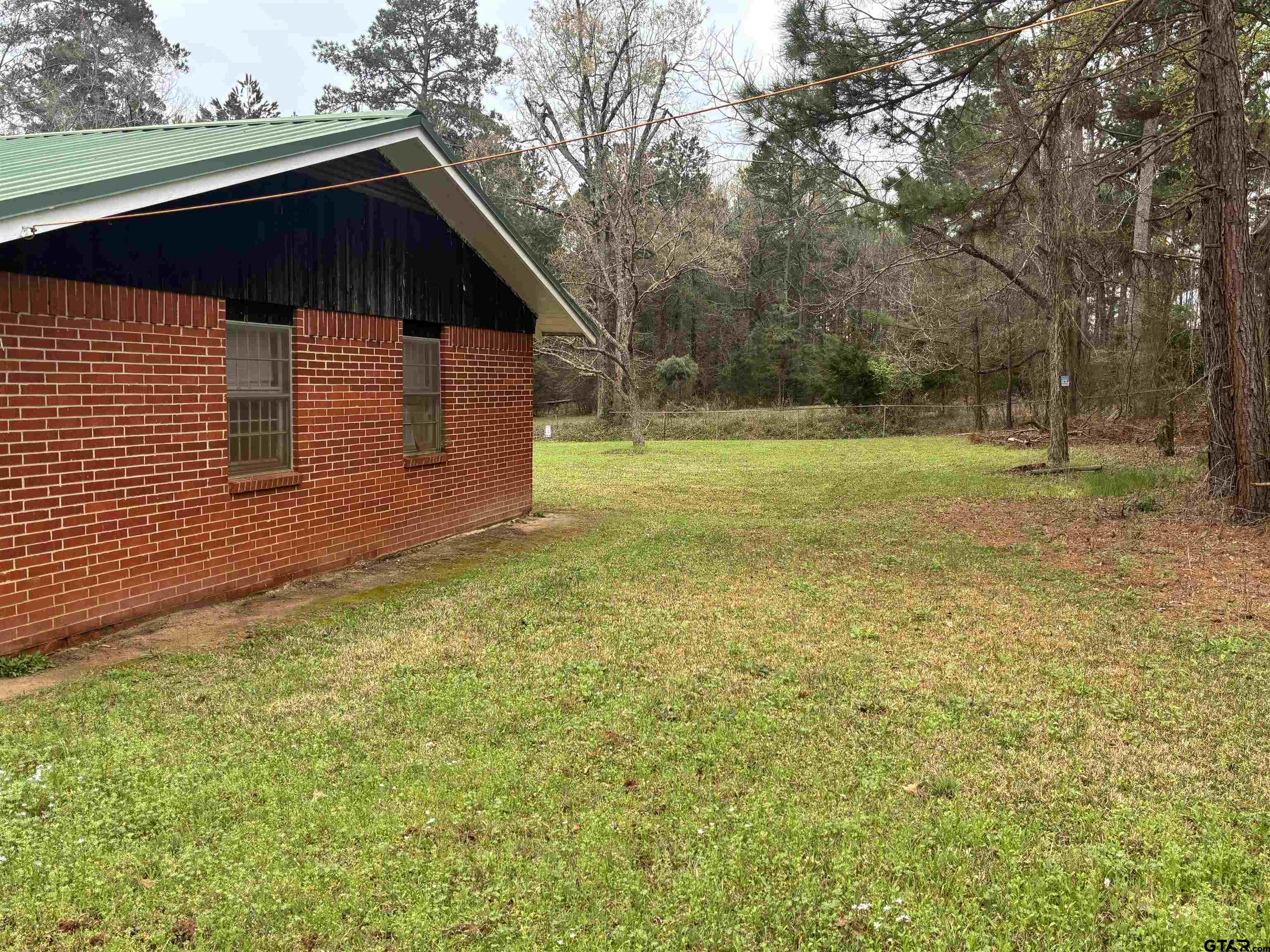 683 County Road 1209 Rusk, TX 75785 - Photo 9 of 10 a backyard of a house with large trees and wooden fence