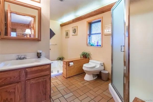 a bathroom with a toilet sink vanity granite and mirror