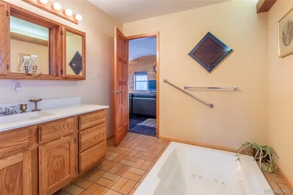 a bathroom with a tub sink and mirror