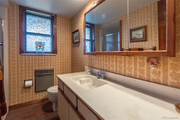 a bathroom with a sink a toilet and mirror