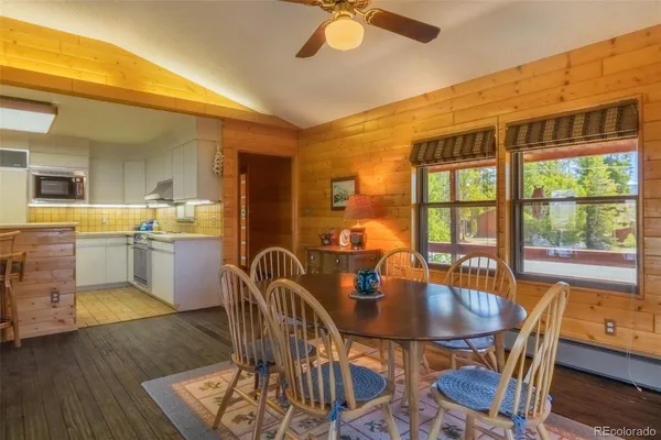 a dining room with furniture a chandelier and wooden floor