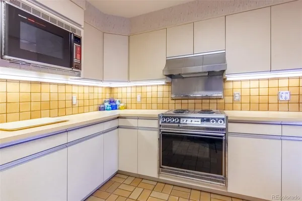 a kitchen with granite countertop a stove top oven cabinetry a sink and a window