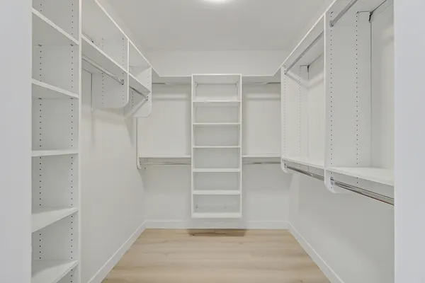 a view of walk in closet with empty racks
