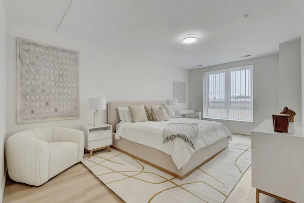 a spacious bedroom with a bed and a couch with window