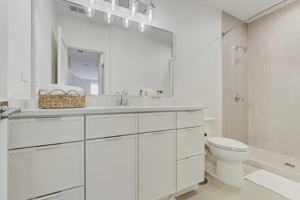 a bathroom with a granite countertop sink toilet a mirror and shower
