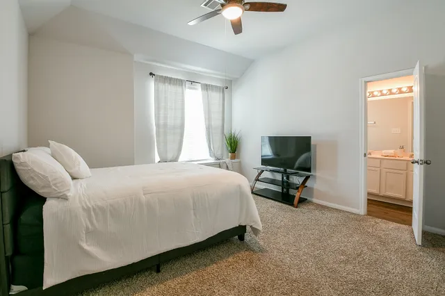 a bedroom with bed and a chair